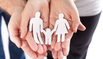 family cupped hands showing paper man family