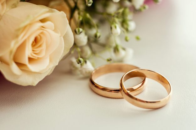 wedding rings lie on a beautiful wedding bouquet, wedding rings lie on a roses, bridal accessories