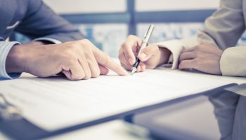 Female hand signing contract