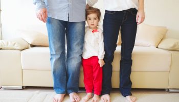 girl hugging mom and dad's legs