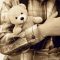 sepia image of little boy holding a teddy bear