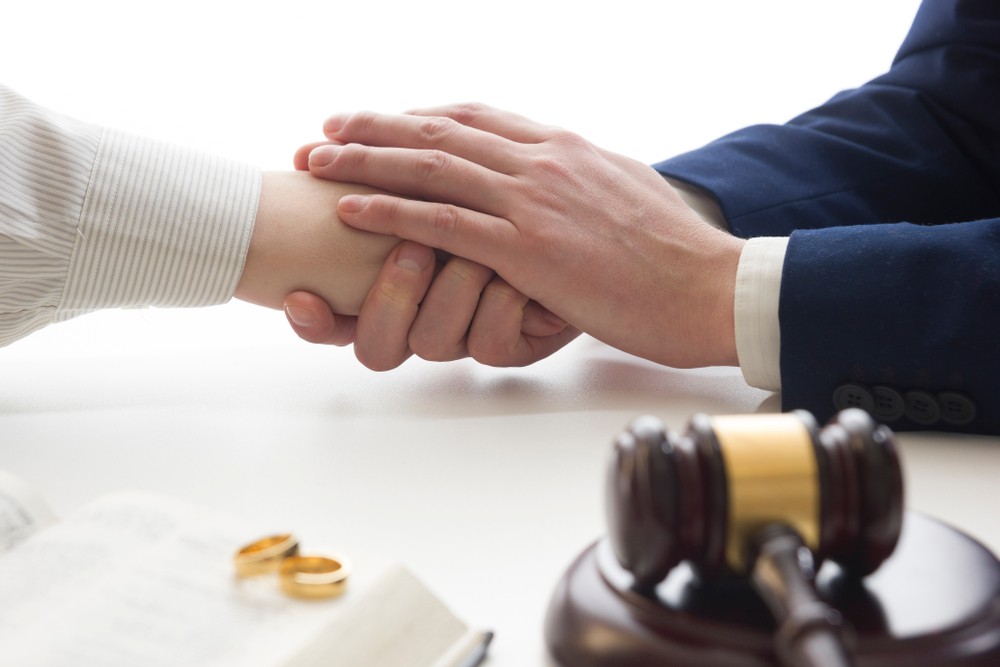 Hands of wife, husband signing decree of divorce